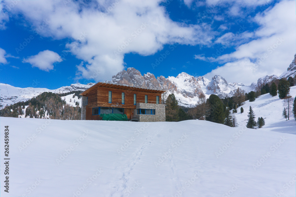 Juac hut on a sunny day in winter with snow and ice in the italien dolomites, south tyrol near wolkenstein