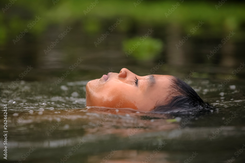 Fototapeta premium Boy swimming in the cannal near the Damnoen Saduak Floating Market