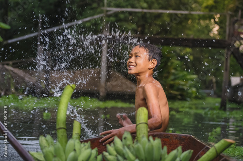 Boy swimming in the cannal near the Damnoen Saduak Floating Market photo