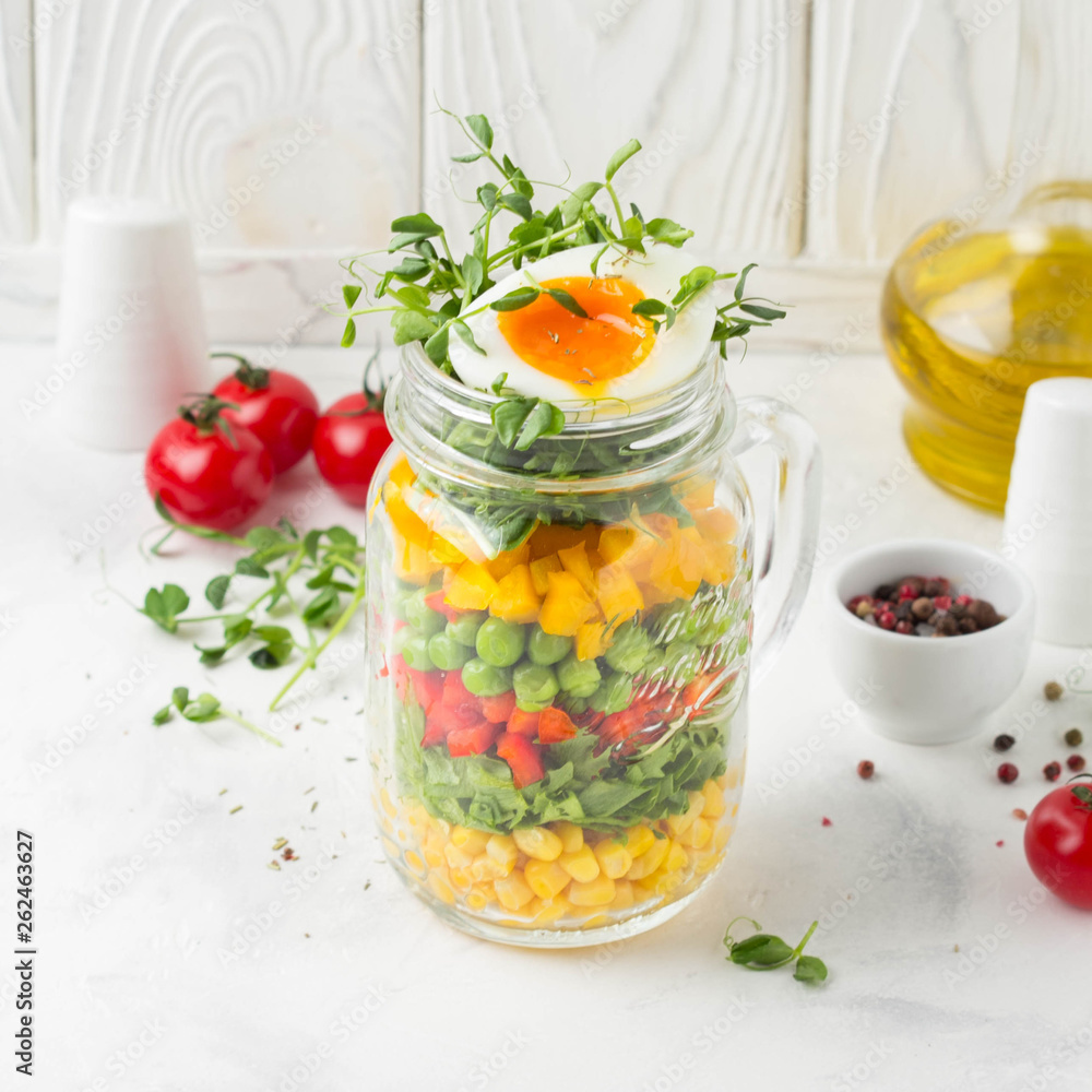 Fresh salad in jar with soft boiled egg, liquid yolk. Corn, green lettuce, bell pepper, peas. Delicious food, healthy lunch Fresh salad in jar with soft boiled egg, liquid yolk. Corn, green lettuce, bell pepper, peas. Delicious food, healthy lunch