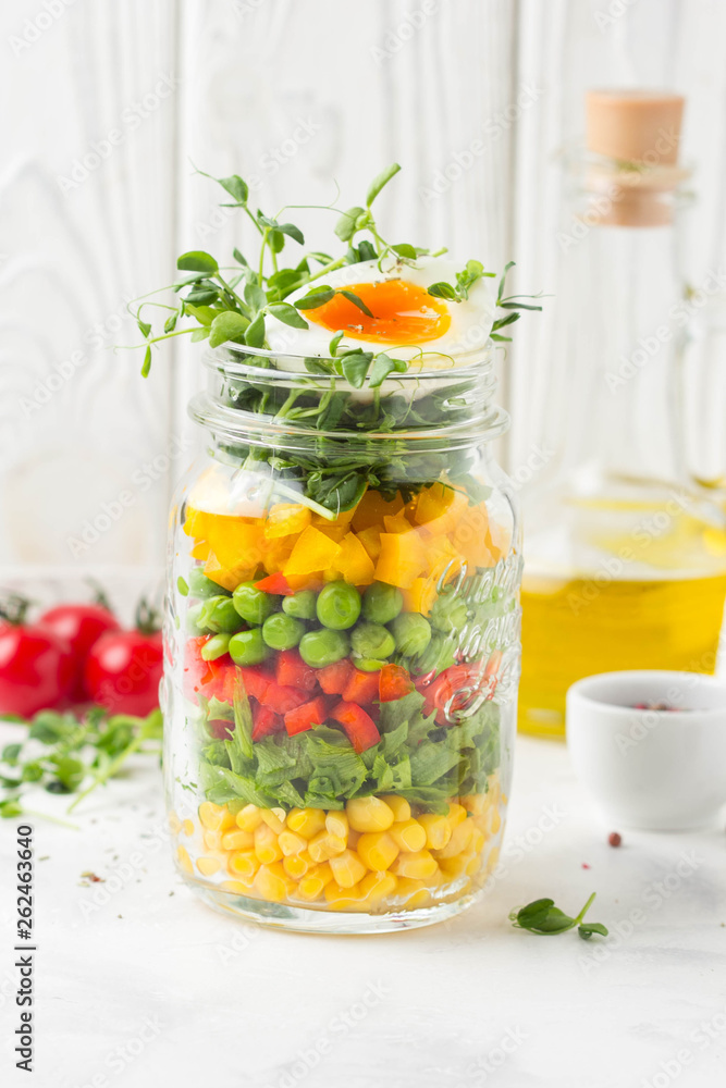 Fresh salad in jar with soft boiled egg, liquid yolk. Corn, green lettuce, bell pepper, peas. Delicious food, healthy lunch Fresh salad in jar with soft boiled egg, liquid yolk. Corn, green lettuce, bell pepper, peas. Delicious food, healthy lunch