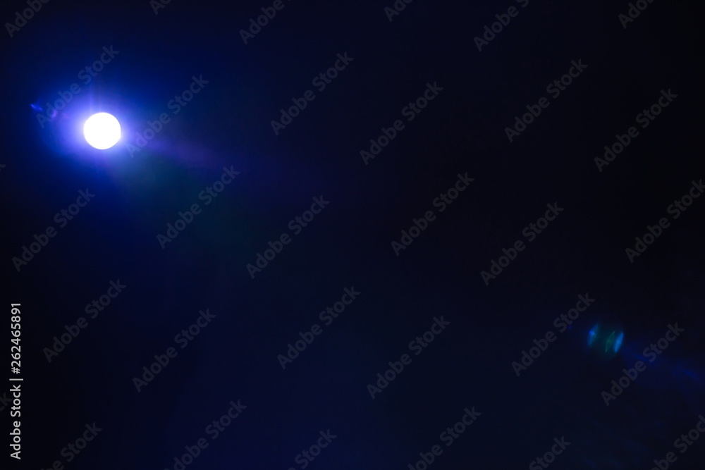 projector spotlight blue and purple color . light beam flare and glowing for movie cinema and film multimedia production in dark black room at night . videography background , copy space