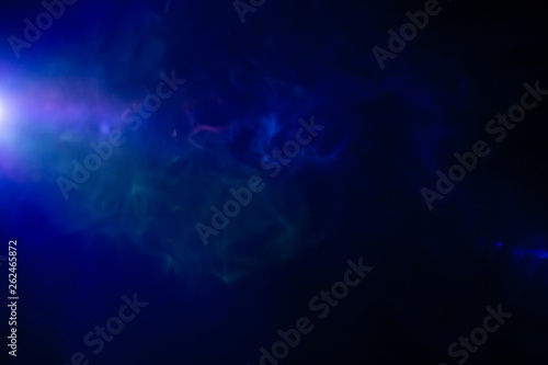 projector spotlight on smoke texture background . light beam screening and glowing for multimedia production in dark black room at night . fractal shape of mystery gas in the air , copy space