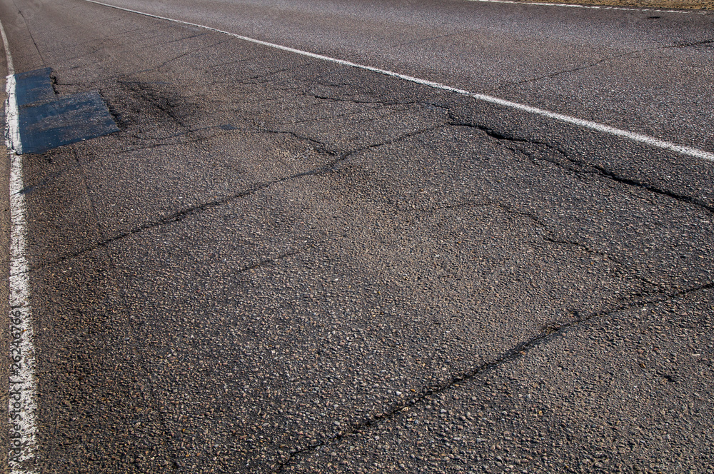 Fototapeta premium Old asphalt road with cracks
