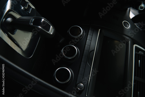 black buttons near modern car dashboard and gear shift in automobile
