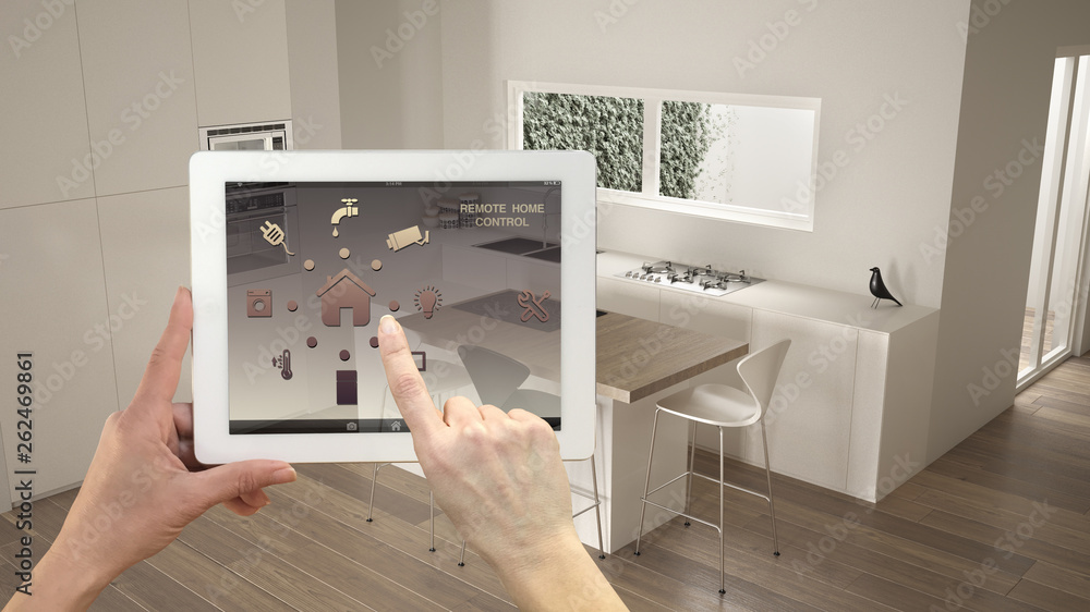Smart remote home control system on a digital tablet. Device with app icons. Minimalist modern bright kitchen in the background, architecture interior design Smart remote home control system on a digital tablet. Device with app icons. Minimalist modern bright kitchen in the background, architecture interior design