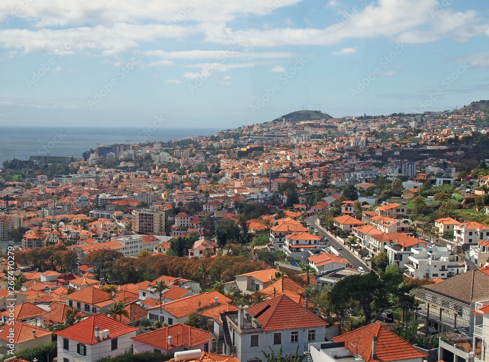 overhead panoramic view of the city of funchal in madeira with roofs and landmarks of the city visible in front of the sea