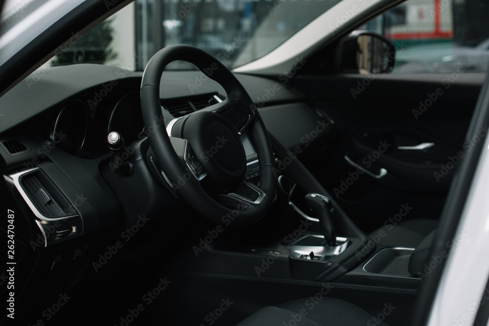 black steering wheel near gear shift handle in luxury car