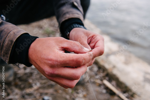 Fisherman puts a worm on the hook