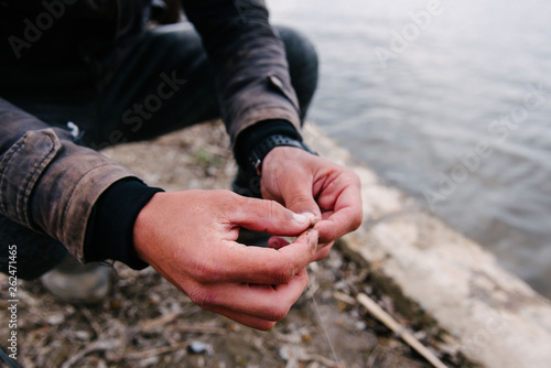 Fisherman puts a worm on the hook