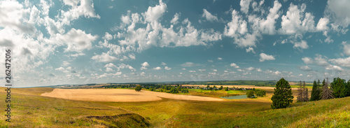 Panoramic high angle view of the plain, the village and the lake from hill top.