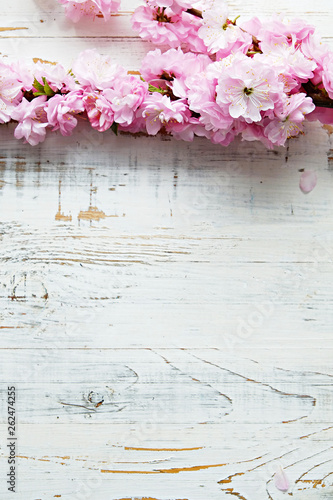 Bunch of spring flowering branches with a lot of white-pink blossoms on wooden background. Rustic composition w/ spring flowers on vintage textured wood table. Close up, copy space, top view.