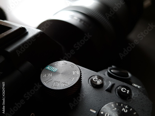 A photo camera with the mode selector wheel on top for shutter, aperture and manual control (pasm).