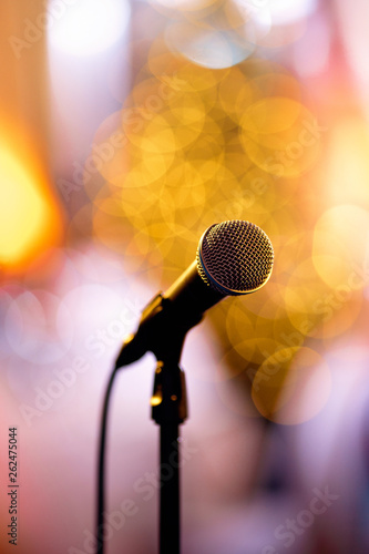 Isolated bokeh microphone on a concert stage with artists redy to perform in the backstage photo