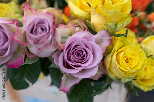 A top down view of bunches of multi-coloured roses for sale at a local market  including pink  red and yellow