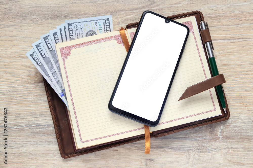 Organizer with us dollars and smartphone modern frame less design with isolated blank screen for copy space on the background of a desk Organizer with us dollars and smartphone modern frame less design with isolated blank screen for copy space on the background of a desk