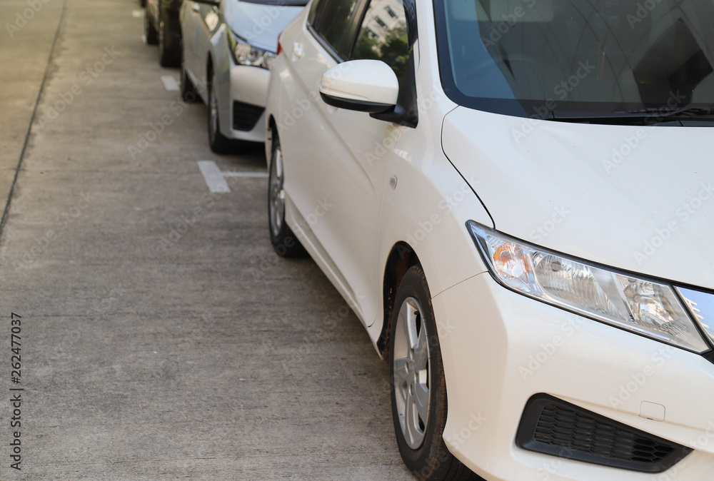 Closeup of front side of white car parking in parking area beside the street. Closeup of front side of white car parking in parking area beside the street.
