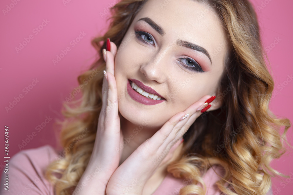 Fototapeta premium portrait of beautiful girl with hands near face on pink studio background, concept of youth and natural beauty