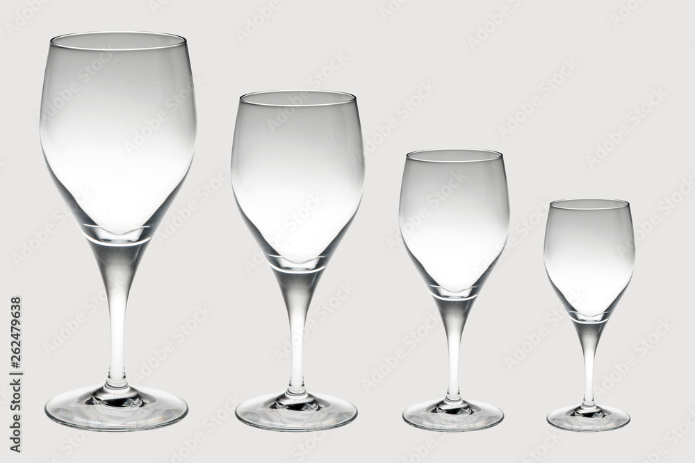 four crystal wine glasses in decreasing size isolated on white background