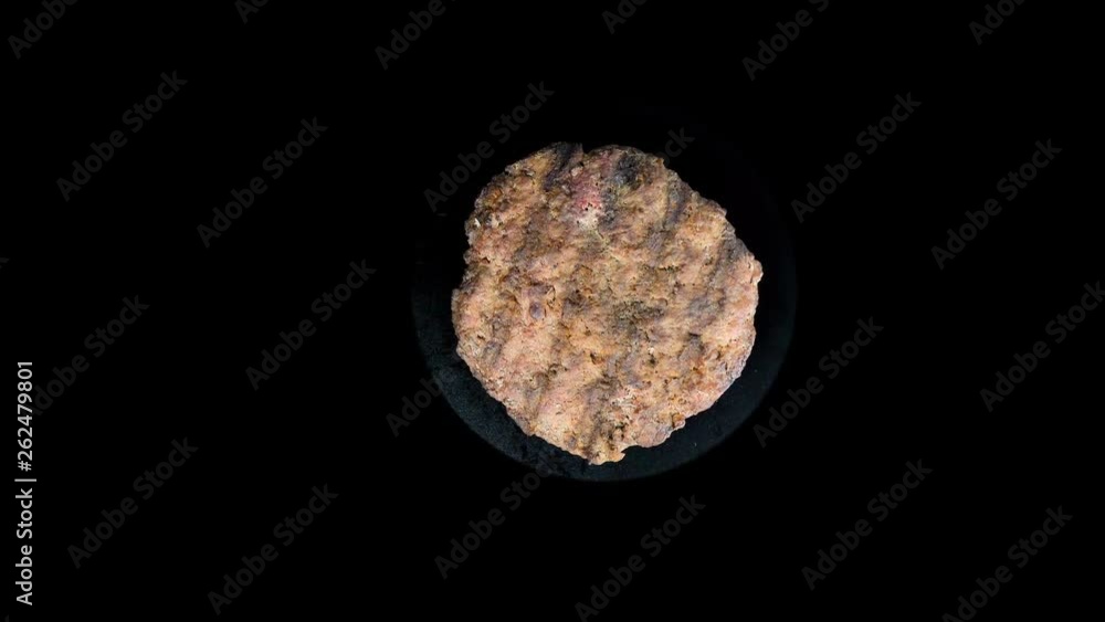 Burger patty rotates on an isolated black background, cooking Round patty, top view Burger patty rotates on an isolated black background, cooking Round patty, top view
