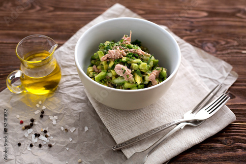 Salad with tuna, avocado, salt, parsley and lemon. Top view. Organic. Vitam. Healthy food. Homemade. Wooden table. Paleo diet.