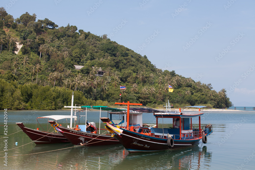 Colorful boats with flags on Koh Samui. Transport on island.
