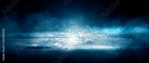 Dark street and wet asphalt. Night view of the city, reflection of the glare in the water, neon blue light. Dark street background.