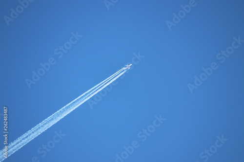 Trail of jet plane on clear blue sky. Airplane in the sky with contrail