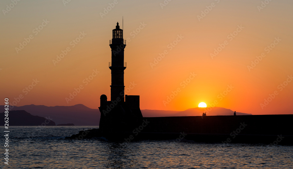 The silhoutte of the lighthouse in the harbor of Chania, a city on the island of Crete, Greece during sunset.