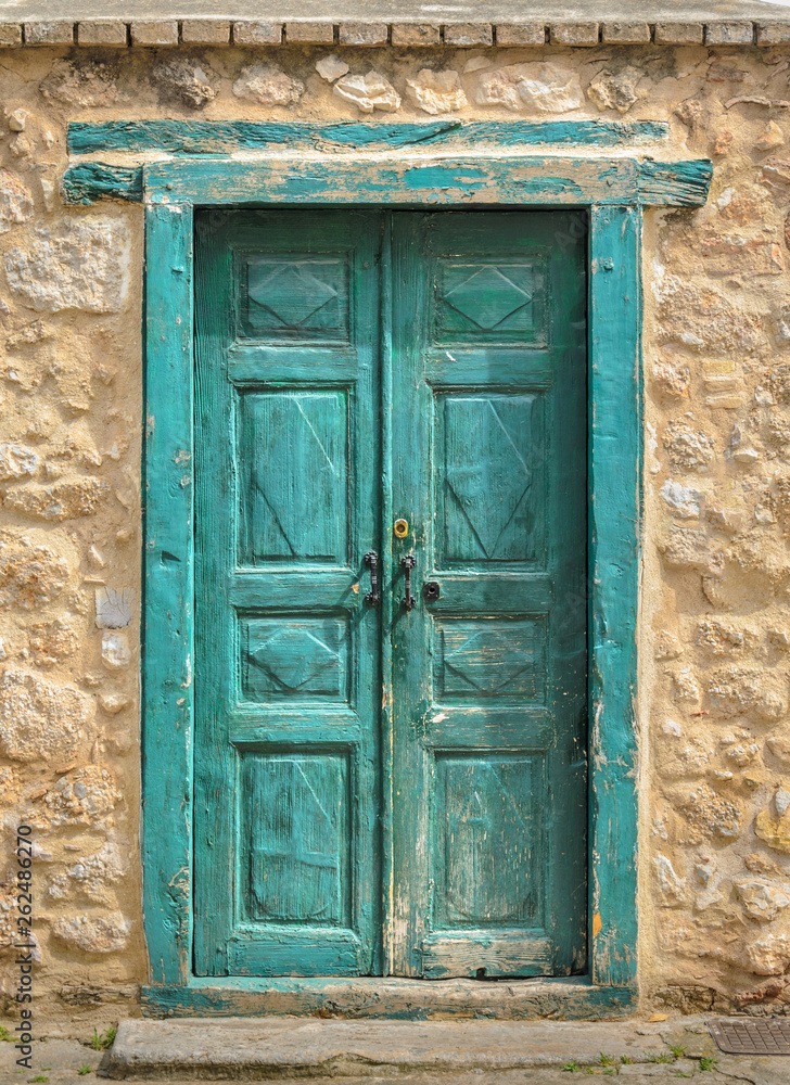 An old wooden traditional petrol green door in Galaxidi Greece