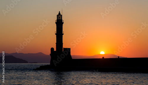 The silhoutte of the lighthouse in the harbor of Chania, a city on the island of Crete, Greece during sunset. © Sebastian