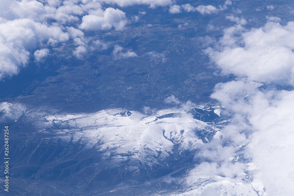 view of the snowy peak of a mountain seen from the airplane window