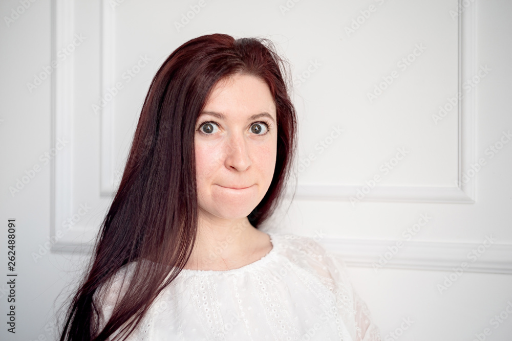 portrait of young caucasian woman with red hair in white shirt on white background portrait of young caucasian woman with red hair in white shirt on white background