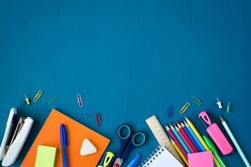 School supplies on blue background. Top view. Copy space.