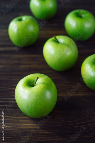 Group of green apples on brown wooden background. Close up