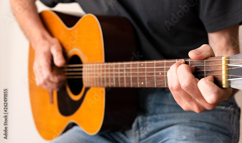 Man finger picking a C chord whilst playing an Acoustic Guitar