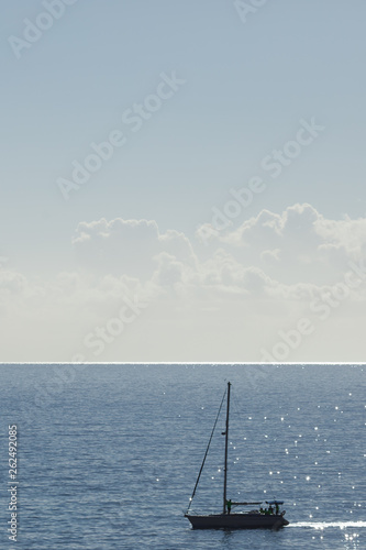 clouds on the sky and blue sea with yacht silhouette