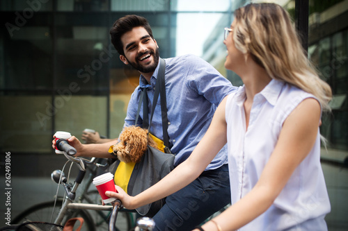 Beautiful couple walking dogs and bicycles outdoors in city © NDABCREATIVITY