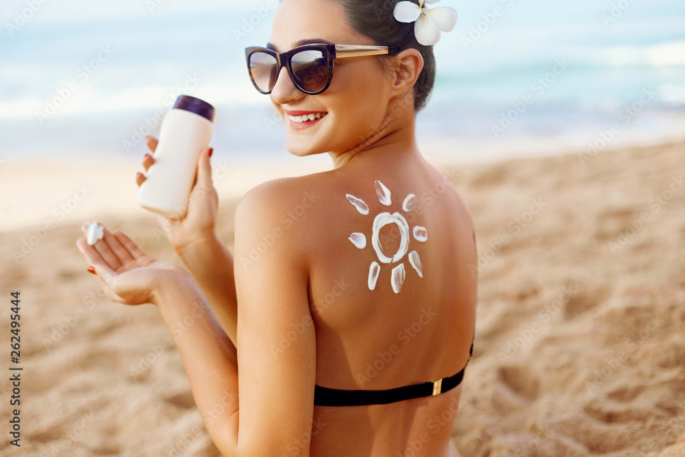 Woman apply Sun cream on tanned back. Skin and Body Care. Sun
