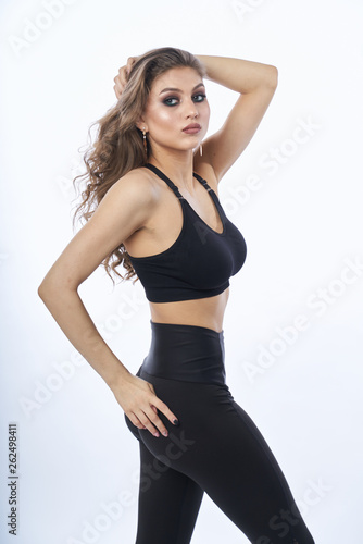Beautiful girl in swimsuit posing against grey white background