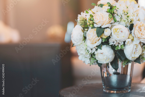 glass vase with white bouquet flower decprative items in living room home interior concept photo