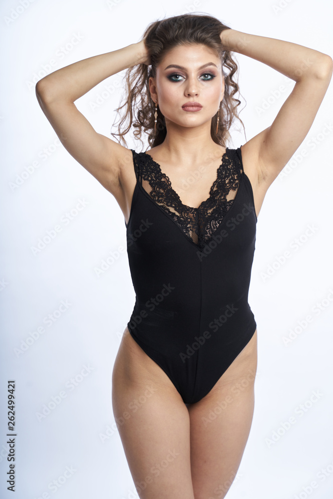 Fototapeta premium Beautiful girl in swimsuit posing against grey white background