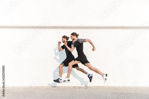 Full length of two healthy fit twin brothers exercising