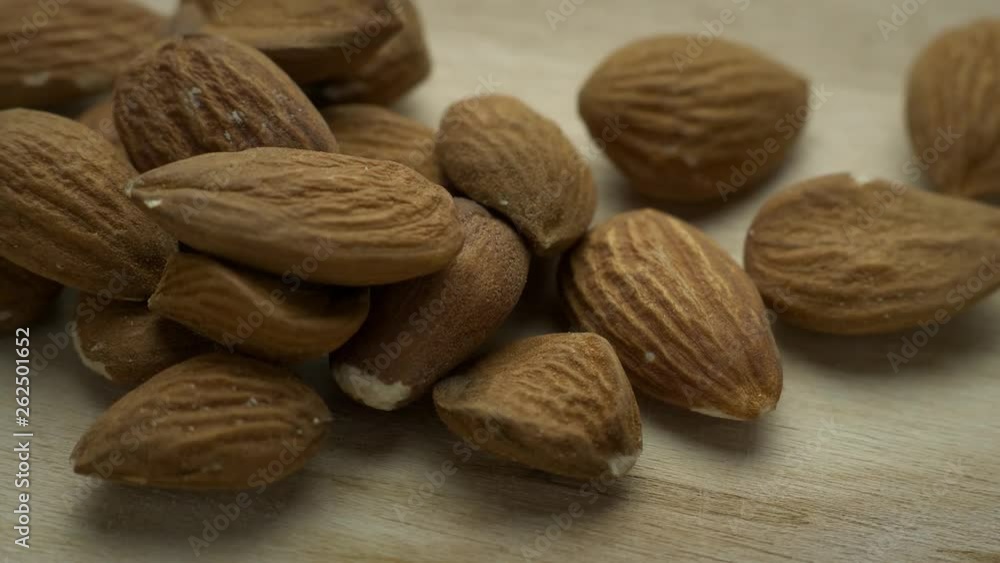 Almonds rotates on a wooden board; closeup macro shot. Almonds rotates on a wooden board; closeup macro shot.