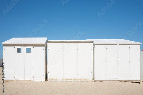 white beach houses, cabines in Blankenberg, Belgium, against blue sky