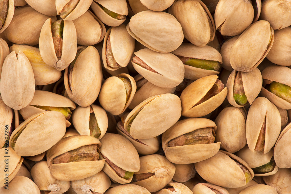Top view on a stack of salty pistachio nuts as abstract background. Copy space for your text.