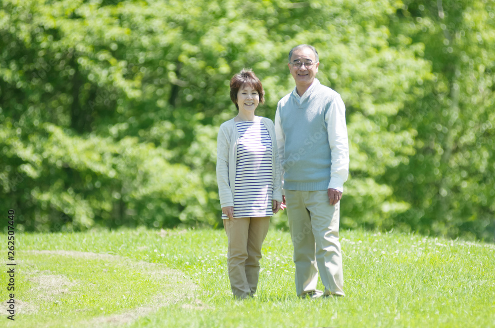 草原で微笑むシニア夫婦