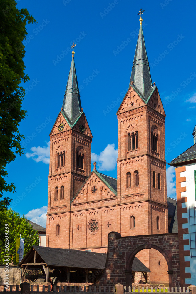 Fototapeta premium Perfect portrait view of the two Romanesque Revival towers at the west façade of the historic Basilika St. Marcellinus und Petrus, also known as Einhard-Basilika in Seligenstadt, Germany.