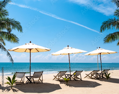 Fototapeta Naklejka Na Ścianę i Meble -  Beautiful scenery of chairs and white umbrellas on the beach, the sea of relaxation in the summer. Copy space banner
