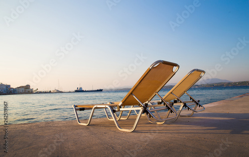 2 chairs near water. Sunset photo